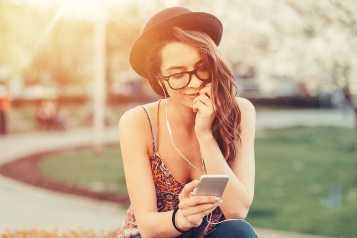 Young woman enjoying the music and text messaging