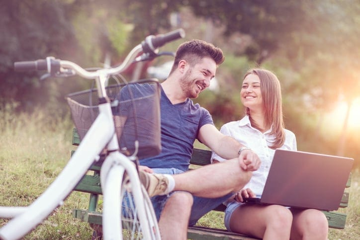 Couple sat bench laughing