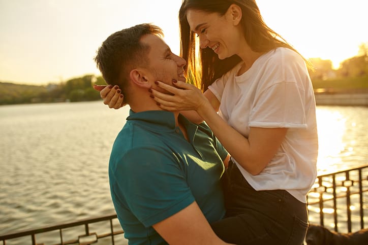 Happy couple having great time together - photographed at sunset against sun