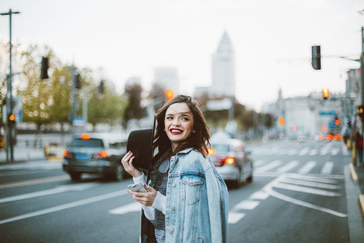 Stunning beautiful woman with red lipstick out in the city, on a lovely day.