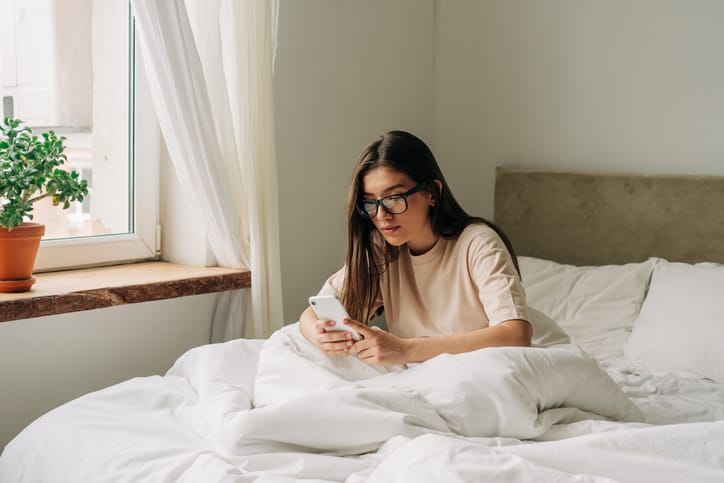 woman texting in bed