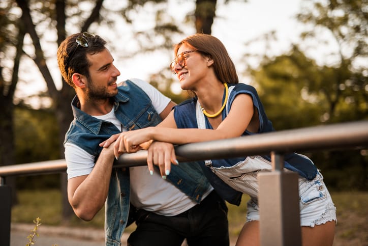 Young happy man talking to his girlfriend at the park.