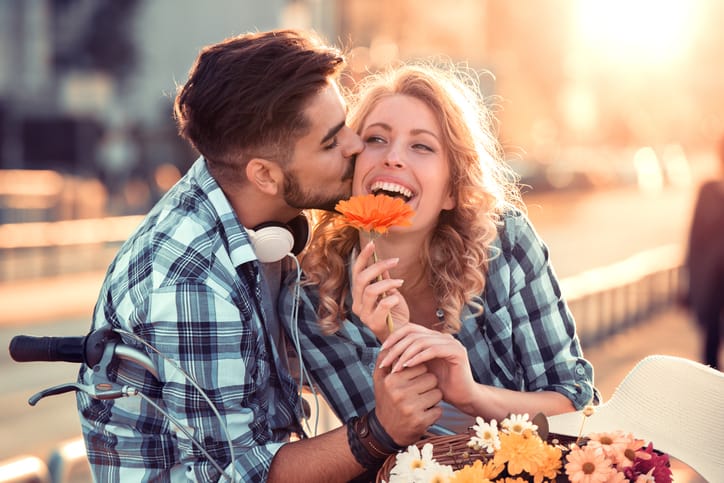 Happy young couple hugging and laughing outdoors.