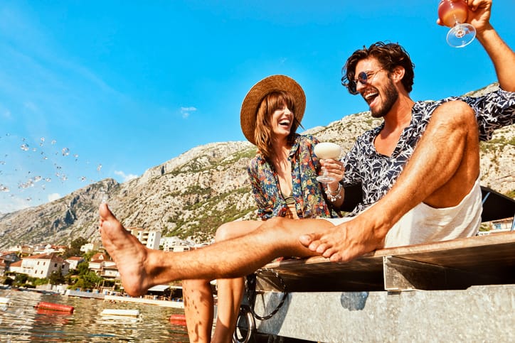 Happy couple sitting on pier in summer.