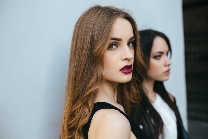 Two young and beautiful girl posing on a white background