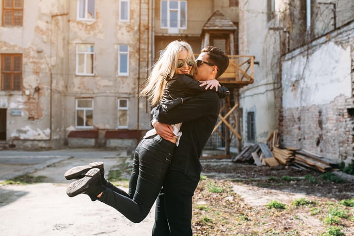 Young man holds his beautiful girl on hands