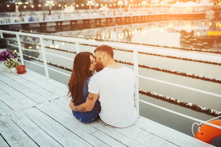 beautiful couple posing on a wooden pier at lake