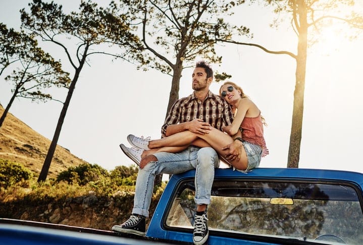 Shot of an affectionate couple pulling over to admire the scenery while on a road trip