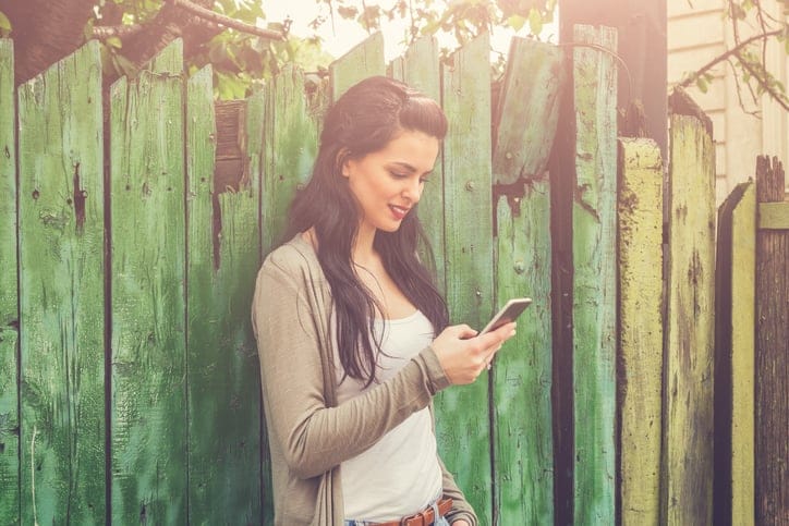 Young urban girl with cellphone outdoors.