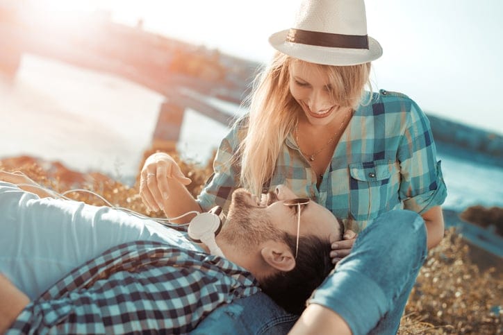 Happy young couple hugging and laughing outdoors.