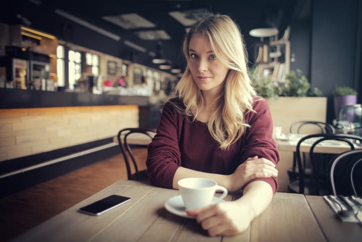 Young woman is drinking a coffee in a bar