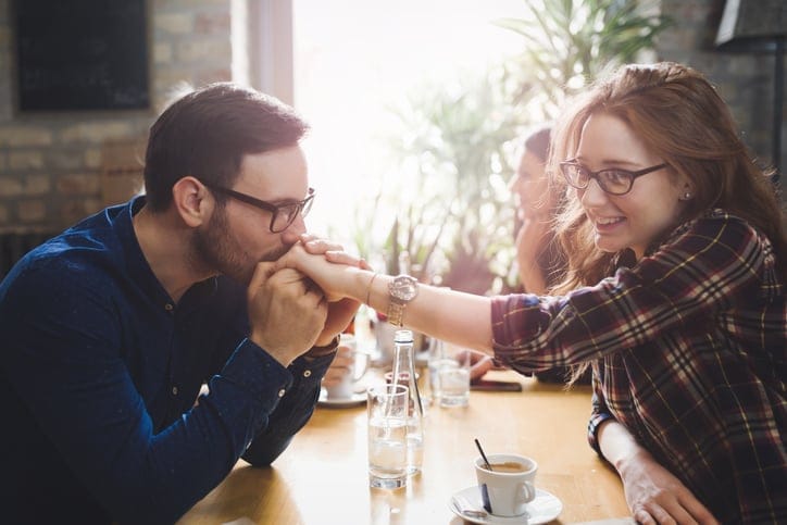 Happy beautiful couple flirting and dating in restaurant