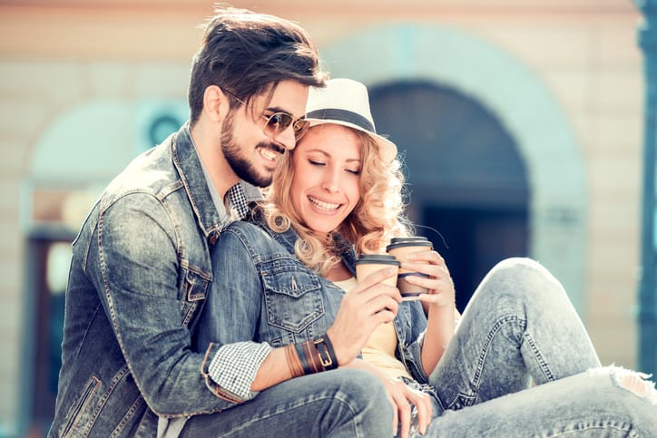 Happy young couple hugging and laughing outdoors.
