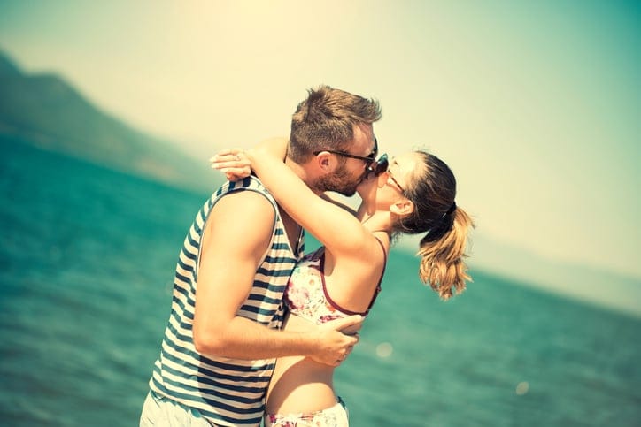 Attractive Summer Couple how Kissing at Sunset by the Sea