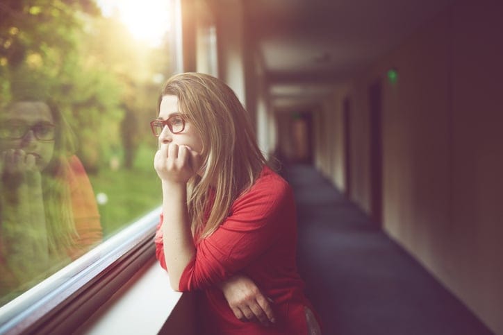 sad and nostalgic woman looking on window and contemplating her thoughts.lifestyle concept.