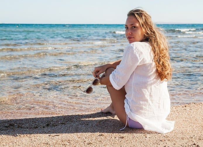 Young woman beach sitting