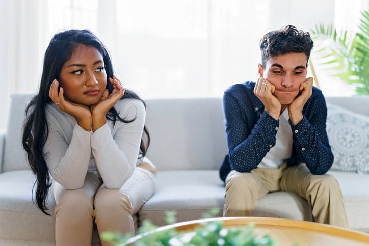 unhappy couple sitting on couch