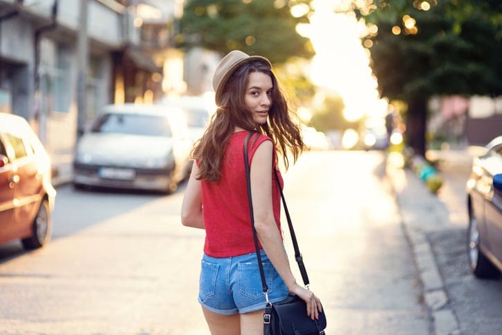 Girl walking on the street and looking behind her back