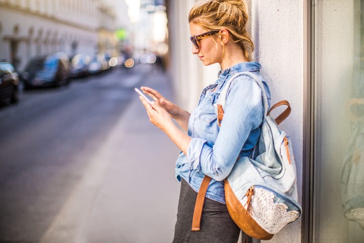 Photo of stylish woman using a smartphone outdoors