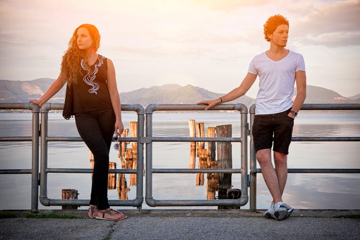 Young italian couple standing by lake.