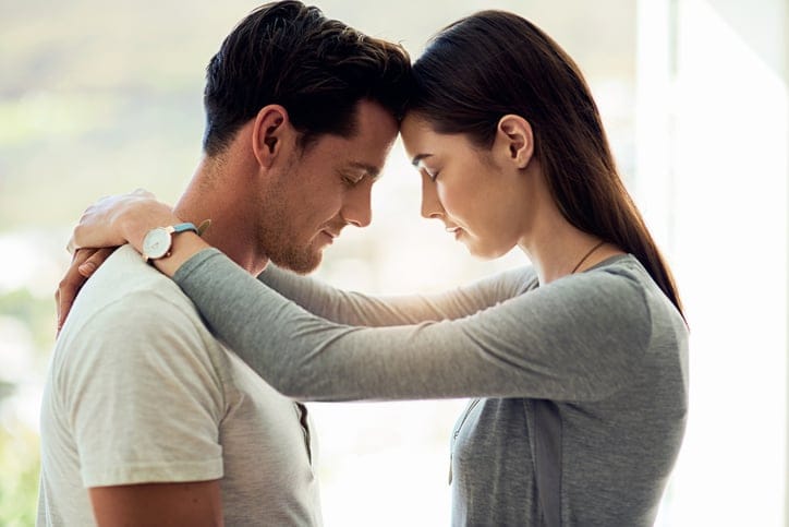 young couple heads together serious