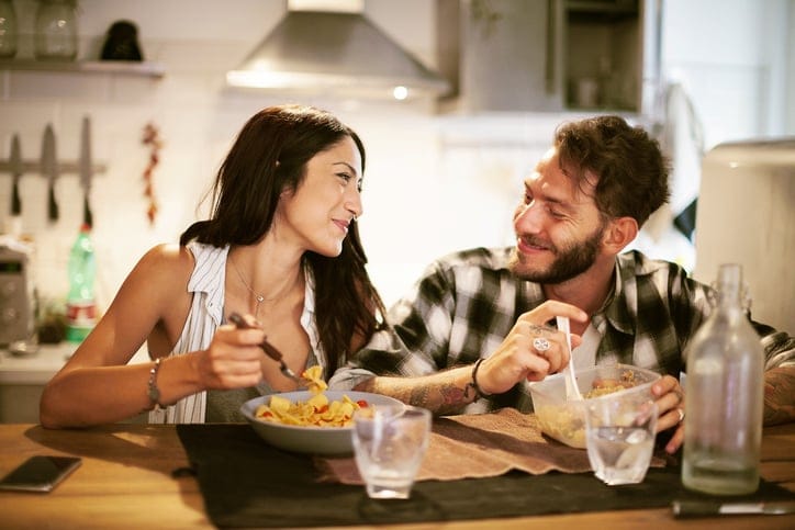 Young couple eating together at home