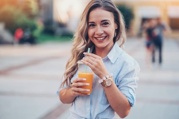 Woman drinking fresh juice outdoors.