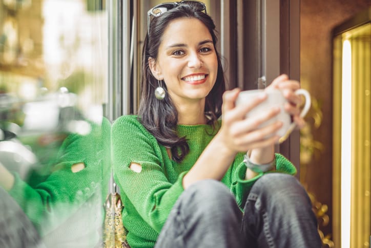 Young woman enjoying a cup of coffee on a rainy day