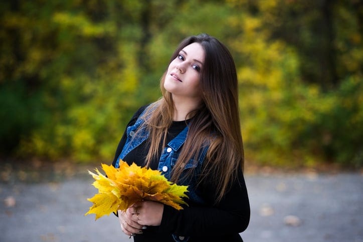 Plus size model in jeans vest outdoors, xxl woman autumn
