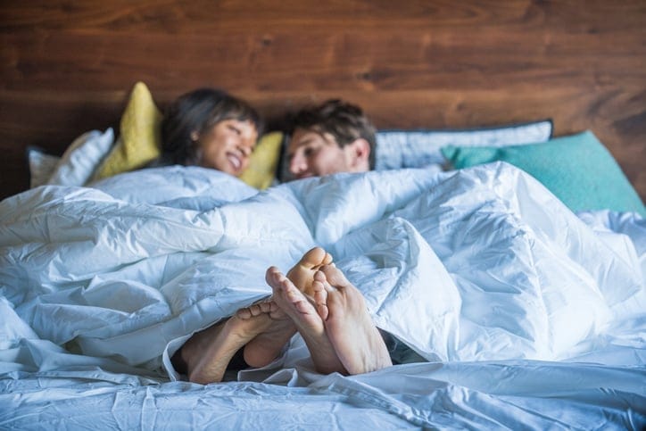 Multi Ethnic Couple in Bed being playful