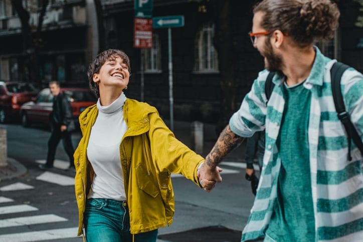 couple holding hands crossing street