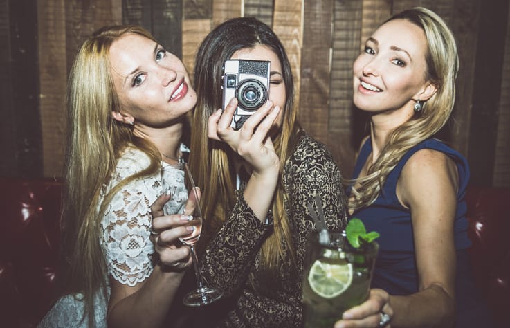 Party girls in a restaurant celebrating with drinks and champagne