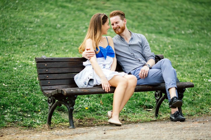 Couple in love spending time in nature on park bench