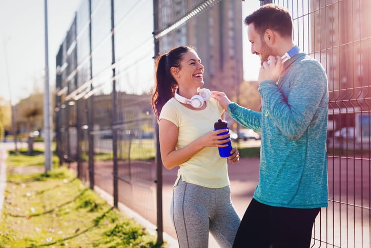 Handsome man and attractive woman talking on court