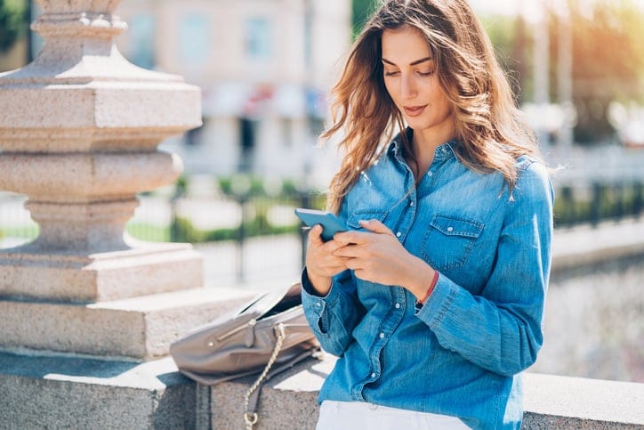 Young woman with smart phone outdoors in the city