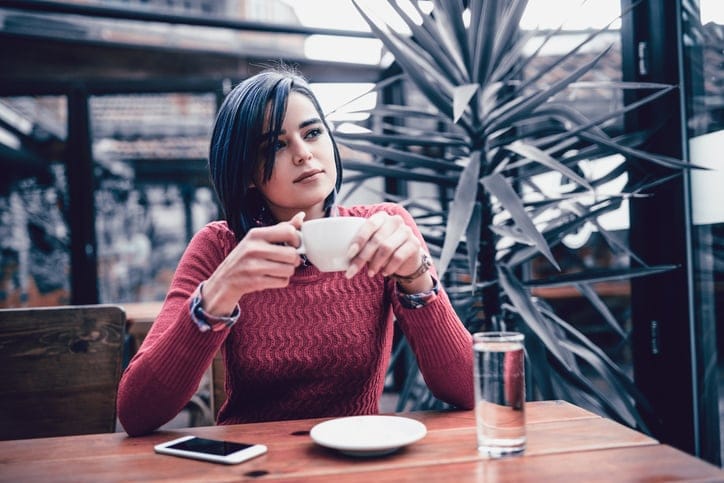 Young Smiling Female Enjoying Coffee Break at the Restaurant in the Morning