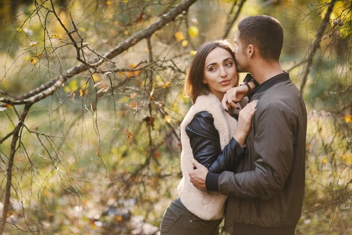 lovely couple walking around the park during autumn