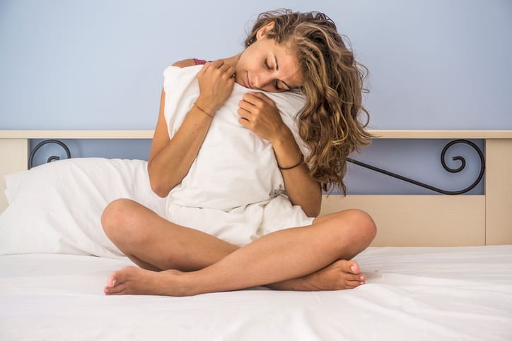 woman with a pillow on bed