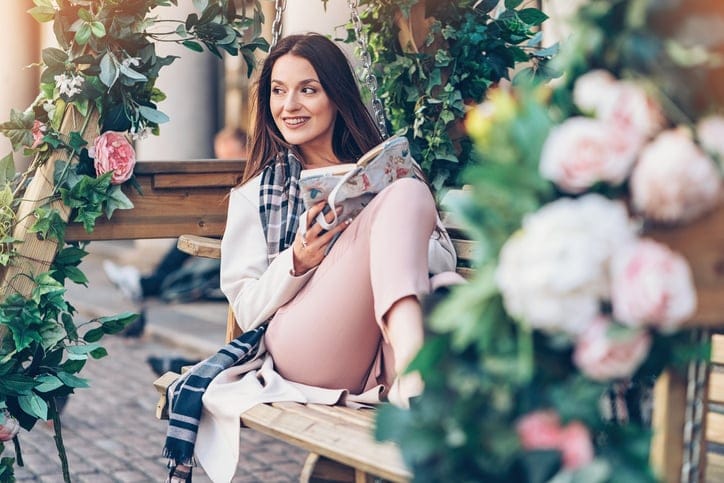 Beautiful young woman relaxing with a book outdoors