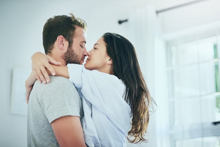 couple kissing in the bedroom standing
