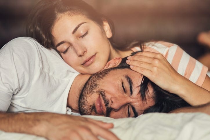 Young loving couple taking a nap in bed.