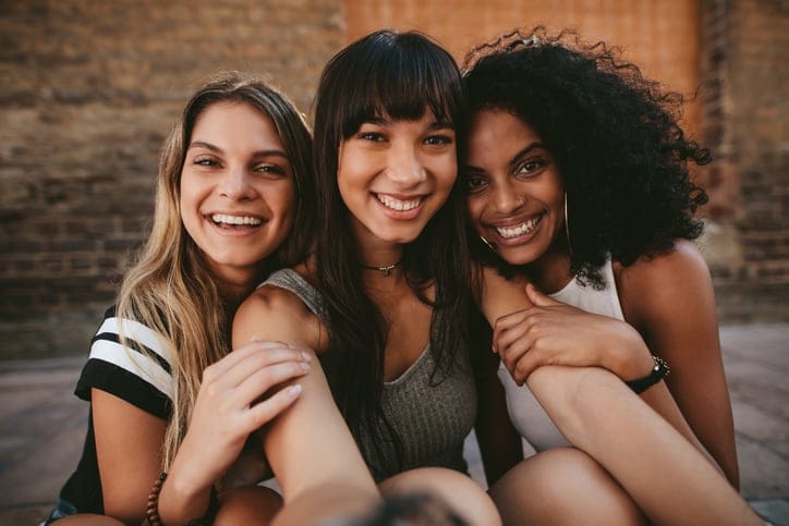 Female friends smiling together.
