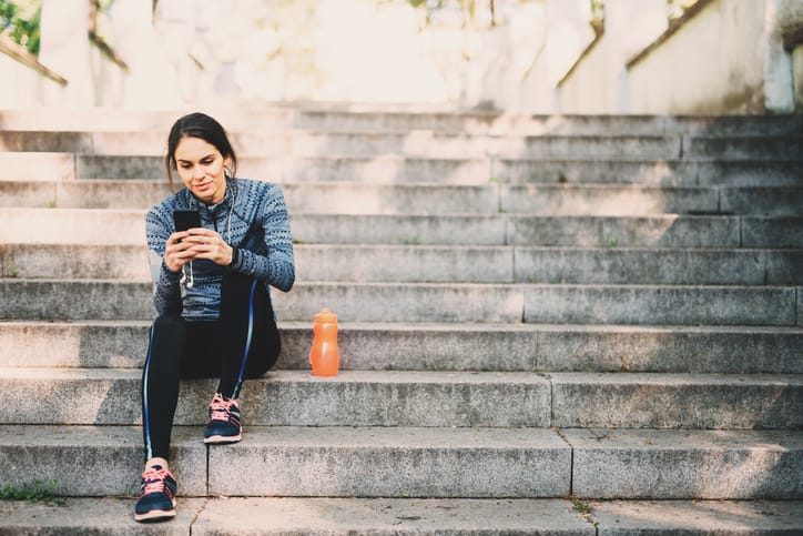 woman sitting on the steps texting