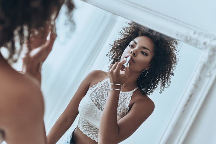 Woman applying lipstick.