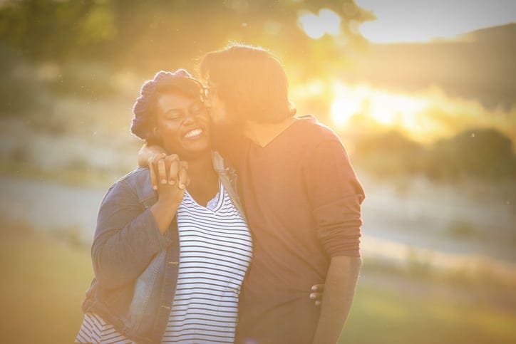 young couple in the sunset kissing