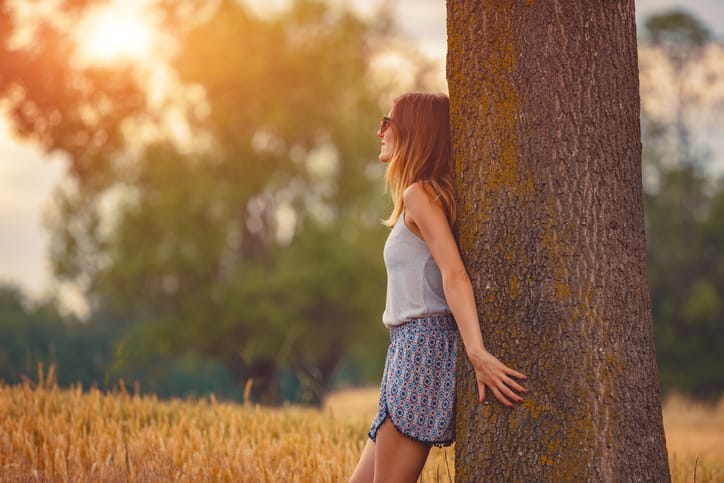 Cute smiley girl embracing the oak tree in nature.