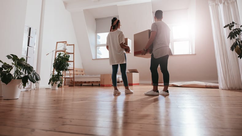 Couple moving boxes together.