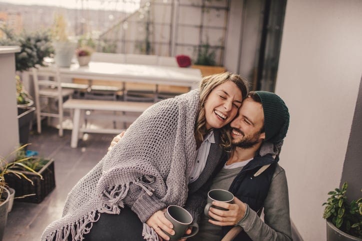 young couple hugging under a blanket