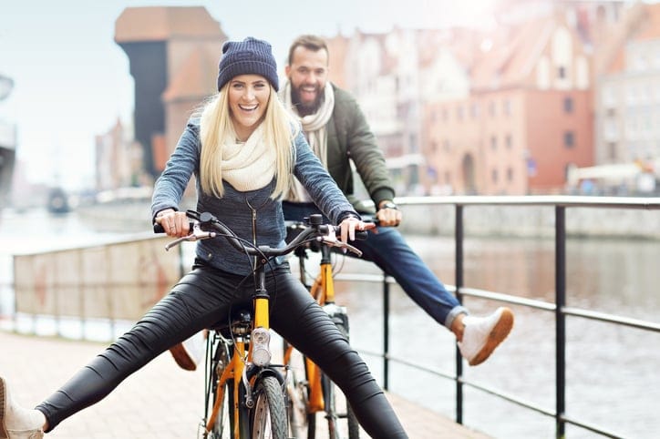 Young couple riding bikes and having fun in the city