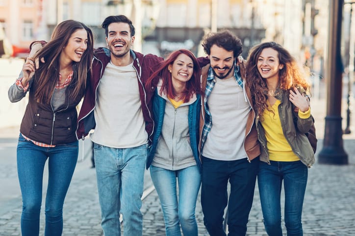 Group of five young people smiling together